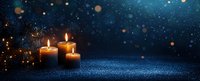 Glowing candles creating warm ambiance against dark blue background with bokeh lights, perfect for holiday or spiritual atmosphere.
