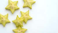 Fresh star fruit slices arranged on white background showing tropical carambola cross-sections with natural star shape for healthy eating and exotic cuisine.