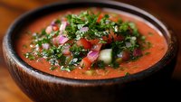 Fresh gazpacho cold soup with diced vegetables and herbs in wooden bowl, healthy Mediterranean cuisine for summer dining and restaurant menus.
