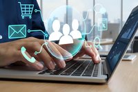 Businessman hands typing on laptop with digital icons overlay showing e-commerce, communication and customer service symbols for online business solutions.