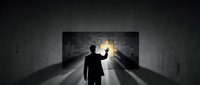 Businessman silhouette holding torch illuminating dark tunnel with brick wall, symbolizing leadership, guidance, and finding solutions in challenging situations.