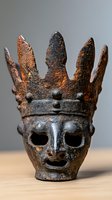 Ancient rusted metal crown skull artifact with pointed spikes and tribal features on wooden surface against neutral gray background.