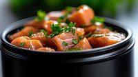 Fresh raw salmon cubes garnished with chopped parsley and sesame seeds in black ceramic bowl, close up view with selective focus on moist fish pieces.