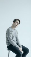 Young man experiencing depression sitting on chair with closed eyes and tilted head showing mental health struggles and emotional exhaustion.