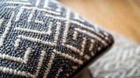 Close-up macro shot of black and white geometric pattern textile fabric with intricate weaving detail showing texture and craftsmanship on decorative cushion.