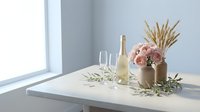 Elegant table setting with pink roses, champagne bottle, glasses and wheat stems in neutral vase creating sophisticated dining atmosphere for celebrations.