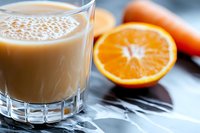 Creamy citrus smoothie in glass with fresh orange slices, nutritious breakfast or healthy beverage for wellness and diet.