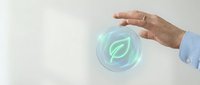 Business hand protecting glowing green leaf icon symbolizing environmental responsibility and sustainable corporate practices for eco-friendly solutions.