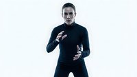Young man with dark hair and fair complexion wearing dark navy sweater gestures expressively with both hands against white background. Suitable for business communication, emotion, presentation, and corporate training materials.