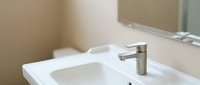 Modern bathroom sink with stainless steel faucet and white countertop in contemporary home interior design setting.