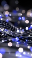 Abstract wavy lines with glowing blue and white bokeh lights on dark background, creating magical festive atmosphere. Suitable for holiday designs and celebrations.
