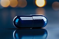 Dark blue medical capsule on reflective surface with blurred bokeh lights in background, dramatic studio lighting creates pharmaceutical atmosphere.