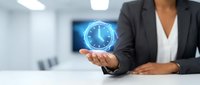 African American businesswoman in formal dark blazer and white blouse holding glowing blue digital clock hologram, representing time management and business efficiency in modern office.
