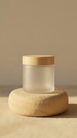 Frosted glass jar with wooden lid displayed on natural wood podium against neutral beige background, suitable for cosmetics, skincare, and product packaging design.