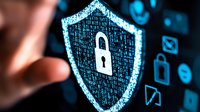 Glowing digital shield with padlock symbol represents cybersecurity and data protection concept against dark background with technology icons and finger touch.
