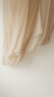 Flowing beige curtains with soft natural light creating elegant drapes and shadows for interior design and home decor projects.