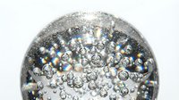 Macro shot of sparkling water droplets and bubbles suspended in clear liquid against white background, isolated for design use.
