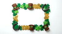 St. Patrick's Day frame with shamrocks, leprechaun hats, horseshoes and gold coins on white background. Irish holiday border for greeting cards.