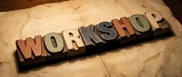Vintage wooden letterpress blocks spelling WORKSHOP on aged paper background for creative design projects and educational materials.