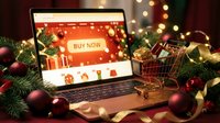 Laptop with Christmas online store and shopping cart filled with gifts surrounded by festive decorations and bokeh lights.