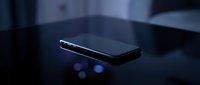 Modern smartphone with glowing blue lights on dark surface, suitable for technology, communication, and digital innovation concepts.