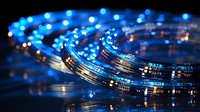 Glowing blue fiber optic cables in spiral formation against dark background create futuristic technology concept for telecommunications and data transfer networks.