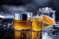 Luxury cosmetic cream and serum jars on black reflective surface with water drops and dramatic lighting, showcasing premium skincare products in golden tones.