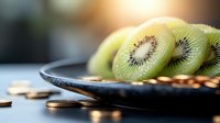 Fresh sliced kiwi fruit arranged on dark plate with scattered golden coins, creating contrast between healthy eating and financial wealth. Selective focus.