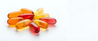 Colorful vitamin capsules and pills scattered on white background, isolated supplement medication for health and wellness nutrition concept.