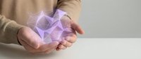Young woman hands holding glowing purple geometric crystal shape with magical light effects for spiritual wellness and energy healing concepts.