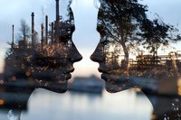 Double exposure silhouettes of faces merged with industrial refinery and nature landscape showing environmental contrast at sunset with bokeh light effects.