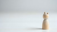 Minimalist wooden cat figurine on clean white background with copy space for modern home decor and design projects.