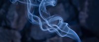 Elegant white smoke swirls rising against dark blue background creating abstract flowing patterns for relaxation and meditation concepts.