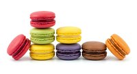 Colorful French macarons in various flavors arranged on white background. Sweet pastry desserts for bakery menu, cafe advertising, culinary projects.