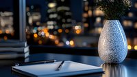 Elegant workspace with digital tablet and decorative vase against blurred city lights at night, creating modern minimalist business atmosphere.