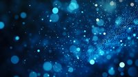 Glowing blue bokeh lights and particles on dark background create magical atmosphere with blurred sparkles and dreamy effect. Digital technology concept.