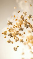 Flying popcorn kernels and fluffy white pieces scattered in air against warm beige background creating dynamic motion effect for food advertising.