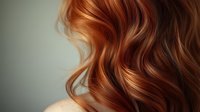 Luxurious wavy auburn hair with golden highlights against neutral background, showcasing healthy shine and texture for hair care and beauty industry use.