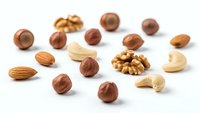 Mixed nuts and dried fruits scattered on white background, healthy snacking ingredients isolated for culinary and nutritional design projects.
