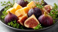 Fresh figs and aged cheese platter with parsley garnish on dark plate, gourmet appetizer arrangement for entertaining and culinary presentations.