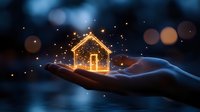 Glowing house silhouette floating above open palm with magical sparkles against dark blue bokeh background, concept of real estate dreams and protection.