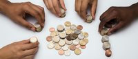 Multiple hands of diverse ethnicities reaching toward and arranging coins on white surface, representing financial planning, savings, investment, money management, and collaborative wealth building for business and personal finance concepts.