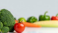 Fresh broccoli and cherry tomato with colorful vegetables on white background for healthy cooking and nutrition concepts.