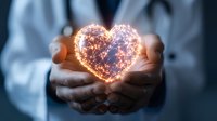 Glowing heart shape made of light particles floating between caring doctor hands against dark background, symbolizing healthcare and healing power.