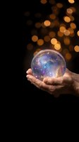 Hands holding glowing crystal ball with cosmic galaxy universe inside against warm bokeh lights background for fortune telling and mystical concepts.