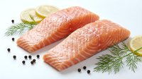 Fresh raw salmon fillets with dill herbs, lemon slices and black peppercorns on white background. Healthy seafood ingredient for cooking and culinary preparation.