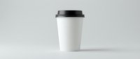 White disposable coffee cup with black lid isolated on gray background for branding mockup and cafe marketing materials.