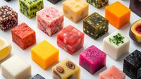 Colorful soap bars in various shapes and textures arranged on white surface, featuring natural ingredients and vibrant hues for cosmetic product display and retail packaging design.