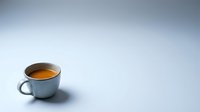 Blue ceramic coffee cup with fresh espresso on clean white background with soft shadow and copy space for text or design elements.