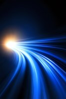 Abstract blue light trails curving into bright point on dark background, creating dynamic motion effect and sense of speed for technology concepts.